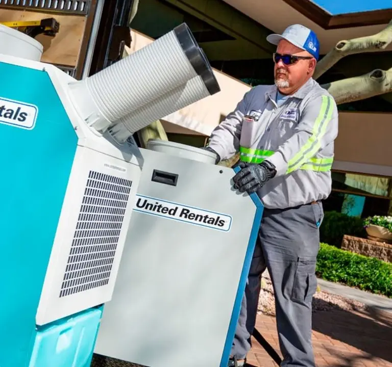 Homme installant des unités temporaires de climatisation United Rentals.