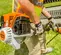 Débroussailleuse STIHL orange, noire, blanche et argent, essence