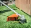 Débroussailleuse STIHL orange et argentée, à essence