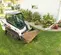 Chargeuse à chenilles compacte BOBCAT blanche et noire sur une pelouse, le godet chargé de terre