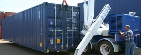 homme livrant un conteneur d’expédition bleu avec une petite grue