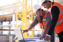 hommes travaillant sur un ordinateur sur le chantier