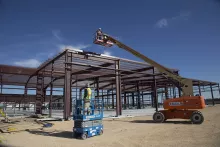 Travailleur à l’intérieur d’un appareil de levage sur le chantier