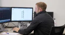 Engineer working at a computer, creating structural designs for construction site safety and temporary support systems.