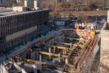 Tranchée ouverte contenant plusieurs tuyaux sur un chantier en activité.